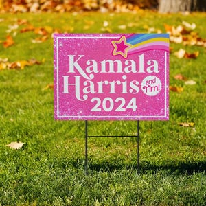 May include: Pink and white yard sign with glitter and a rainbow design. The sign reads "Kamala Harris and Tim! 2024".