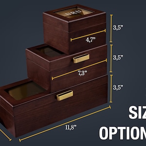 May include: Three wooden boxes with glass lids and gold accents. The boxes are stacked on top of each other and labeled with their dimensions in inches. The largest box is 11.8 inches wide, 4.7 inches tall, and 3.5 inches deep. The middle box is 7.3 inches wide, 4.7 inches tall, and 3.5 inches deep. The smallest box is 4.7 inches wide, 4.7 inches tall, and 3.5 inches deep.