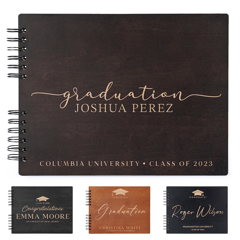 May include: A dark brown wooden photo album with a gold spiral binding. The front cover has the text "graduation" in a cursive font and the name "JOSHUA PEREZ" in a block font. Below the name is the text "COLUMBIA UNIVERSITY CLASS OF 2023".