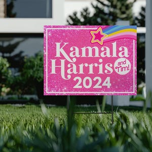 May include: Pink and white yard sign with glitter background. The sign says "Kamala Harris and Tim! 2024" with a rainbow and star graphic.