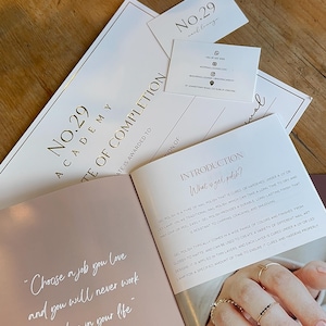Puede incluir: Vista cenital de una mesa de madera con artículos de belleza. Incluye una vela rosa encendida, un certificado de No.29 Academy, tarjetas de visita y un folleto con el texto "Elige un trabajo que te guste y nunca tendrás que trabajar un día de tu vida."