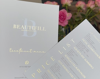 Puede incluir: Dos menús blancos de una clínica estética con letras doradas. Un menú dice "BEAUTIFILL Aesthetics Clinic" y "treatment menu". El otro menú es una lista de precios con servicios como "Lip Enhancement" y "Anti Wrinkle Injections".