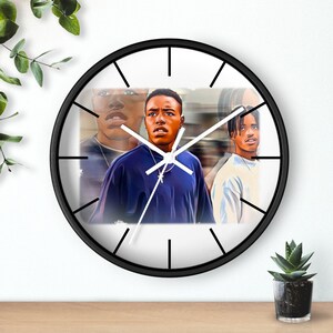 May include: A black and white wall clock with a white face and black hands. The clock face features a colorful image of three young men.