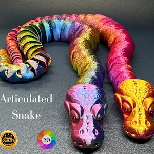May include: Articulated snake toy made of iridescent plastic. The snake is segmented and can be posed in different positions. The snake is rainbow coloured with a red, orange, yellow, green, blue, indigo, and violet colour scheme. The snake has a textured surface and is approximately 50 cm long.