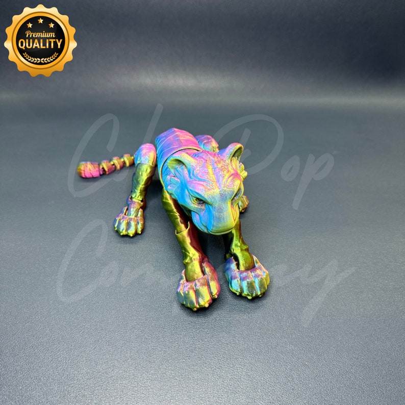 May include: A colorful, iridescent, articulated toy tiger figurine. The tiger is in a crouching position with its head lowered and its paws extended. The toy is made of plastic and has a metallic finish.
