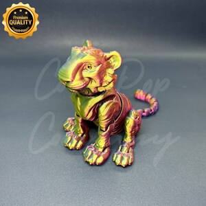 May include: A small, articulated tiger figurine with a metallic iridescent finish. The tiger is sitting with its tail curled around its body. The figurine is made of a durable plastic material and is perfect for collectors or as a decorative piece.