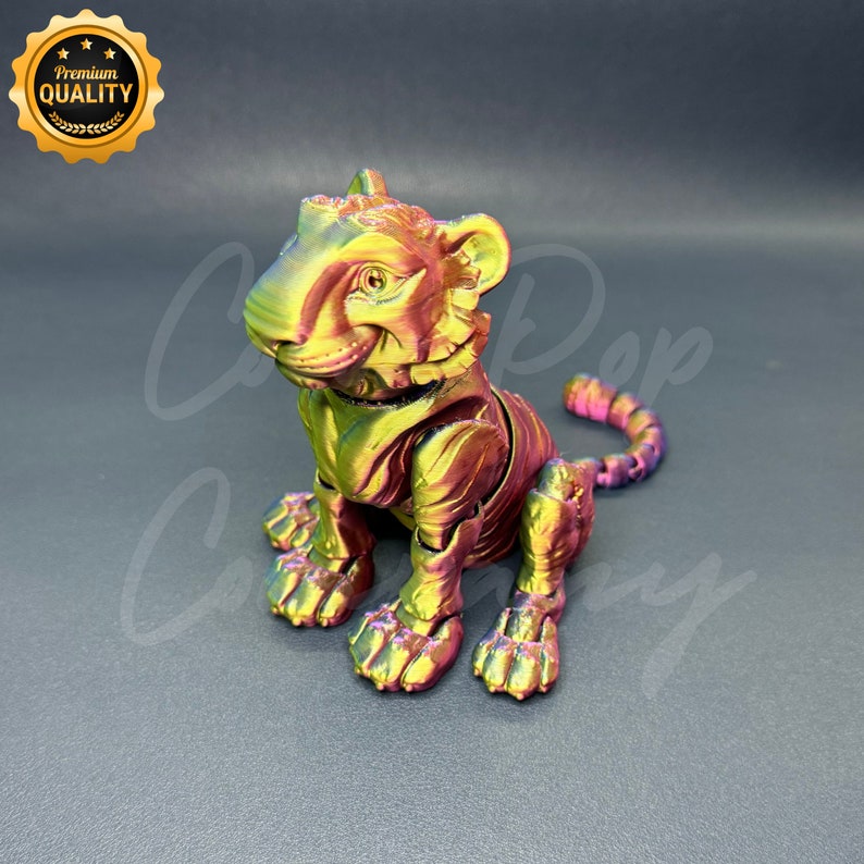 May include: A small, articulated tiger figurine with a metallic iridescent finish. The tiger is sitting with its tail curled around its body. The figurine is made of a durable plastic material and is perfect for collectors or as a decorative piece.