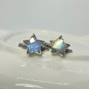 May include: Two silver wire wrapped rings with iridescent labradorite star shaped stones.