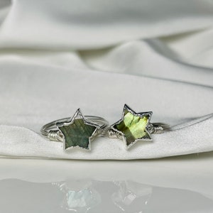 以下が含まれることがあります： 緑のラブラドライトの星型の石が付いた、銀のワイヤーで巻かれたリングが2つです。