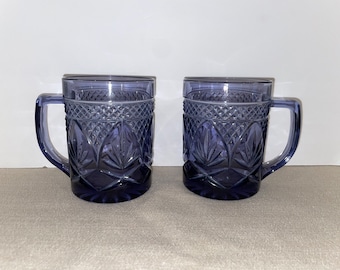 May include: Two purple glass mugs with a diamond pattern and leaf design.
