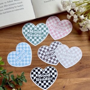 May include: Six heart-shaped stickers with a checkered pattern in various colors, including pink, blue, green, black, and gray. Each sticker features the text "Mood Reader" in a retro font.