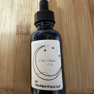 Op de afbeelding: Een donker glazen flesje met een zwarte druppelaar en een wit etiket. Het etiket heeft een zwart halvemaan ontwerp met sterren en de tekst "Lion's Mane 1 oz By ManMade WitchCraft".