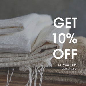 May include: A stack of folded white and beige fabric with the text "GET 10% OFF on your next purchase!" in white letters.