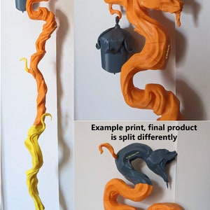 Puede incluir: Un modelo impreso en 3D de una serpiente con una campana en la cola. La serpiente est&aacute; impresa en naranja y gris y se divide en varias piezas para la impresi&oacute;n. El texto "Ejemplo de impresi&oacute;n, el producto final se divide de forma diferente" es visible en la imagen.