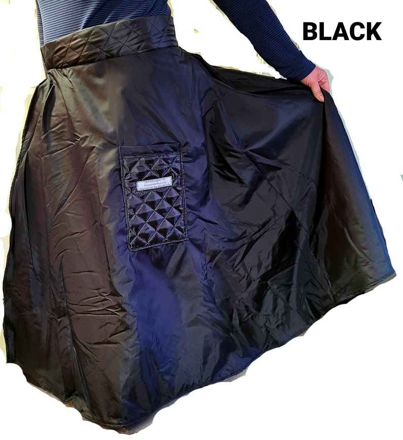 Pode incluir: Uma saia preta acolchoada com um bolso grande na frente. A saia &eacute; feita de um material resistente &agrave; &aacute;gua e tem uma cintura larga.