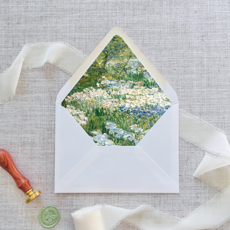 May include: A white envelope with a floral design on the front. The design features a field of blue, white, and pink flowers with green leaves.