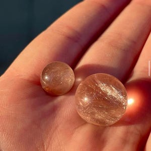 Rare pink rutile in quartz sphere pair