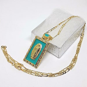 May include: Gold chain necklace with a rectangular pendant featuring a turquoise blue enamel image of the Virgin Mary. The pendant is accented with gold and clear rhinestones.