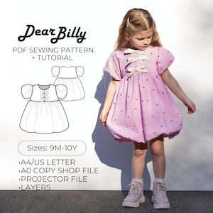 Puede incluir: Una niña con un vestido rosa de cuadros vichy con detalles de corazones rojos y lazos. El vestido tiene mangas cortas abullonadas y una falda fruncida. La imagen también presenta un patrón de costura PDF con el texto "Dear Billy" y "PDF Sewing Pattern + Tutorial". El patrón es para tallas 9M-10Y.