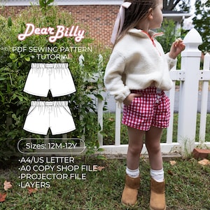 May include: A young child wearing red and white checkered shorts and a cream-colored fleece jacket. The image also features a PDF sewing pattern with the text "Dear Billy" and "PDF Sewing Pattern + Tutorial". The pattern is for shorts, sizes 12M-12Y.