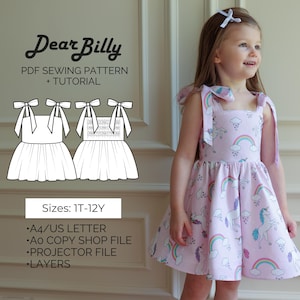 May include: A little girl wearing a light pink dress with a unicorn and rainbow pattern. The dress has square straps tied with bows. The image also shows a PDF sewing pattern with the text "Dear Billy" and "PDF Sewing Pattern + Tutorial".