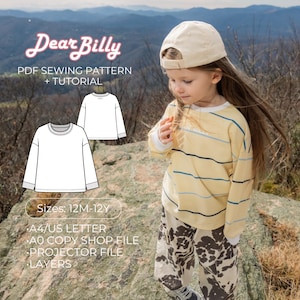 Könnte beinhalten: Ein Kind in einem gelb gestreiften Oberteil und einer gemusterten Hose, mit einer beigen Kappe. Das Bild zeigt eine Grafik eines weißen Langarmshirts und den Text "Dear Billy PDF Sewing Pattern + Tutorial". Größen: 12M-12Y.