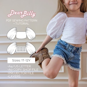 Può includere: Una bambina indossa un top bianco traforato con maniche a sbuffo e pantaloncini di jeans con finiture in pizzo. L'immagine include un modello di cucito con il testo "Dear Billy" e "PDF Sewing Pattern + Tutorial". Il modello è disponibile nelle taglie 1T-12Y.