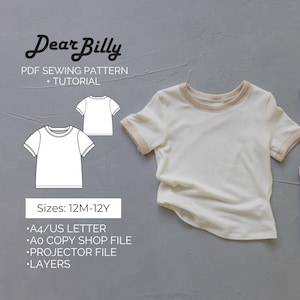 Może przedstawiać: Biały t-shirt z krótkim rękawem i beżowym wykończeniem jest pokazany na szarej powierzchni. Tekst "Dear Billy" i "PDF SEWING PATTERN + TUTORIAL" znajdują się na górze. Poniżej schemat t-shirtu i tekst "Sizes: 12M-12Y".