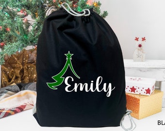 May include: Black drawstring bag with a green Christmas tree design and the name "Emily" in white text.