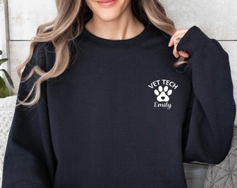 May include: Black sweatshirt with a white paw print and the text "Vet Tech Emily" on the front.