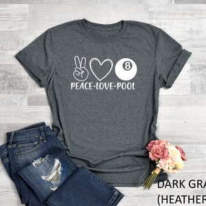 May include: Dark grey heather t-shirt with a white peace sign, heart, and 8-ball graphic. The text "Peace-Love-Pool" is printed below the graphic.