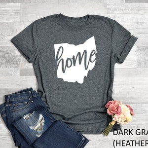 K&ouml;nnte beinhalten: Dunkelgraues T-Shirt mit einem wei&szlig;en Umriss des Bundesstaates Ohio und dem Wort "home" innerhalb des Umrisses.