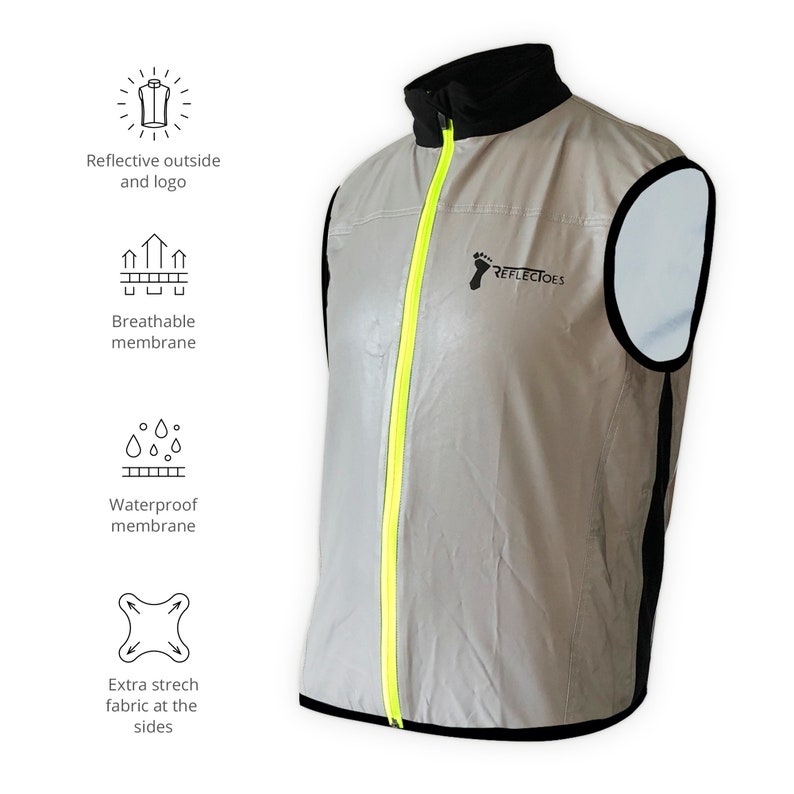 May include: A reflective vest with a black collar and trim, featuring a bright yellow zipper. The vest has the "REFLECTOES" logo and icons indicating a breathable and waterproof membrane, and extra stretch fabric. The vest is designed for visibility.
