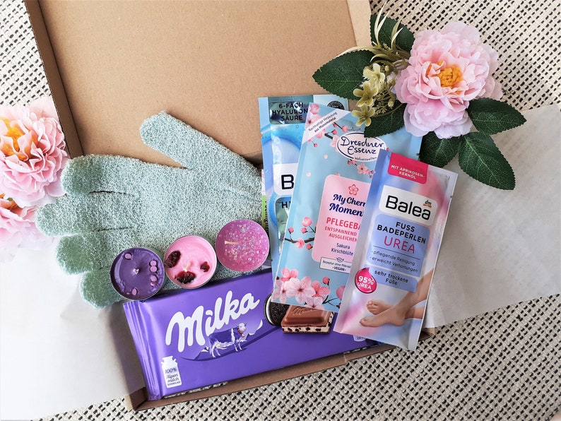 Puede incluir: Una caja de regalo llena de varios productos de ba&ntilde;o y cuerpo, incluyendo bombas de ba&ntilde;o, sales de ba&ntilde;o, un exfoliante para pies y una barra de chocolate. La caja tambi&eacute;n incluye un par de guantes exfoliantes y algunas velas de t&eacute;.