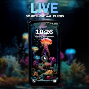 Op de afbeelding: Een live telefoonachtergrond met een donkere achtergrond en een telefoonscherm waarop een klok met de tijd 10:26 en de datum zaterdag 21 september wordt weergegeven. Het telefoonscherm toont ook een afspeelknop en een kleurrijke onderwater scène met kwallen en koraal.