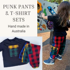 May include: A black t-shirt with a yellow and green plaid chest pocket, paired with multi-coloured plaid trousers featuring red, blue, yellow, and green blocks. The text PUNK PANTS & T-SHIRT SETS Hand made in Australia is visible on the left side.