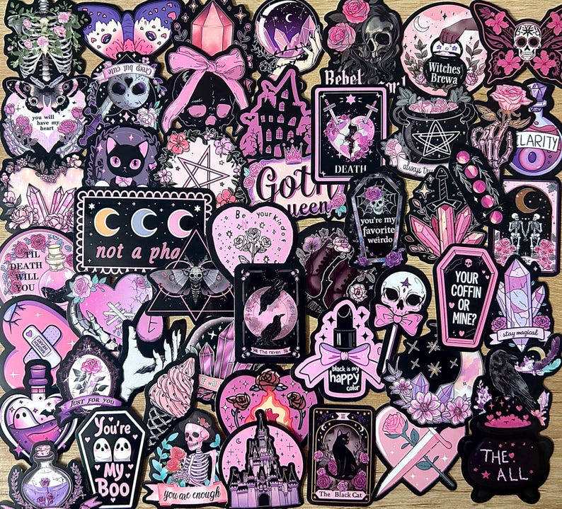 May include: A collection of gothic-themed stickers in various shapes and sizes. The stickers feature skulls, bats, cats, crystals, and phrases like "You're My Boo" and "Your Coffin or Mine?" in black, pink, and purple.