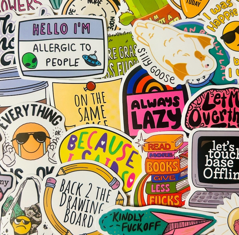 May include: A collection of colorful stickers with various designs and text. Some stickers feature phrases like "Hello I'm Allergic to People," "Always Lazy," and "Back 2 the Drawing Board." Other stickers have illustrations of a goose, a computer, and a stack of books.