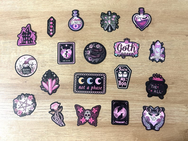May include: A collection of gothic-themed stickers with various designs, including a castle, potion bottles, crystals, a coffin with ghosts, and a butterfly with a skull. The stickers feature pink, purple, and black colors, with text like "Goth queen" and "not a phase".