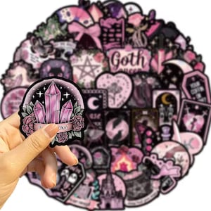 May include: A collection of pink and black goth-themed stickers. One sticker, held by a hand, features pink crystals, roses, and the text "TE OKAY". Other stickers include moons, hearts, stars, and the words "Goth Queen".