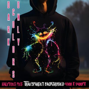 Peut inclure: Un sweat-shirt noir avec un motif coloré et abstrait d'une créature au sourire narquois. Le motif est composé d'éclaboussures de peinture rose, bleue, verte, jaune et orange. Le texte "DO ONLY COLORS" est imprimé verticalement sur le côté gauche de l'image.