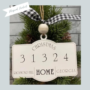 May include: White wooden Christmas ornament with the text "Christmas 31324 Richmond Hill Home Georgia".