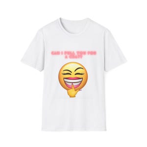 Op de afbeelding: Een wit T-shirt met korte mouwen en een afbeelding van een gele lachende emoji met lange wimpers en een hand die de kin aanraakt. Boven de emoji staat de tekst CAN I PULL YOU FOR A CHAT? gedrukt in een gloeiend rood neon-achtig lettertype.
