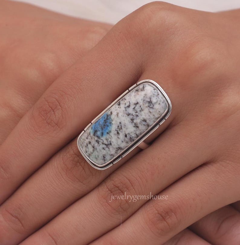 May include: A silver ring with a large rectangular blue and white stone. The stone has a marbled pattern.