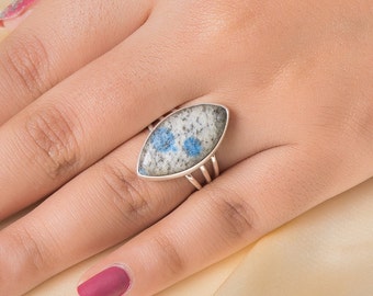 May include: A silver ring with a blue and white marbled stone set in a marquise shape.