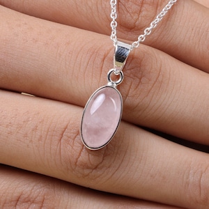 May include: A silver chain necklace with a pink oval rose quartz pendant.