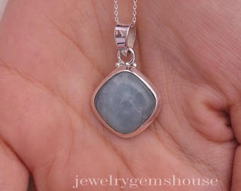 May include: A silver necklace with a square, light blue gemstone pendant. The pendant is set in a silver frame and hangs from a delicate silver chain. The text "jewelrygemshouse" is visible at the bottom of the image.