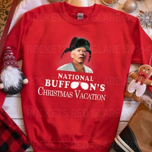 Pode incluir: Camisola vermelha de Natal com um gráfico branco de um homem usando um chapéu verde e óculos de sol com o texto "National Buffon's Christmas Vacation".