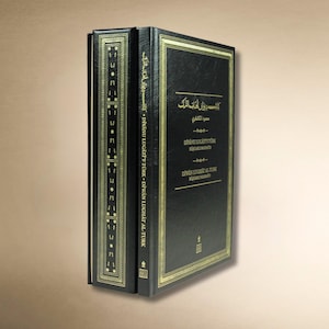May include: A black hardcover book titled Divanu Lugat'it-Turk by Kasgari Mahmut, featuring gold foil lettering and decorative border patterns on the front cover and spine. The book is presented inside a matching black slipcase with gold accents.