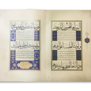 K&ouml;nnte beinhalten: Ein aufgeschlagenes Buch mit zwei Seiten komplexer arabischer Kalligrafie in schwarzer Tinte. Der Text ist von verzierten R&auml;ndern in Blau, Gold und Rot umrahmt, wobei florale und geometrische Muster die zentralen Schriftabschnitte umgeben.